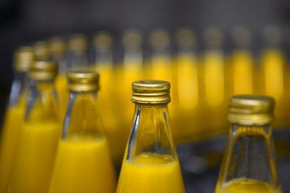 Flaschen mit Orangensaft auf einer Förderanlage.