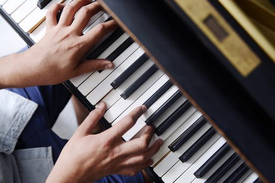 Blick auf Hände, die Klavier spielen.