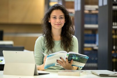 Eine Studentin lernt in einer Bibliothek.