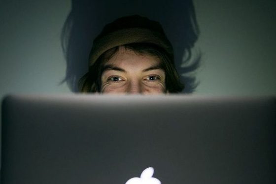 Im Vordergrund ein Laptop, hinter dem ein Mann sitzt. (Foto: Julien Fertl Photography)