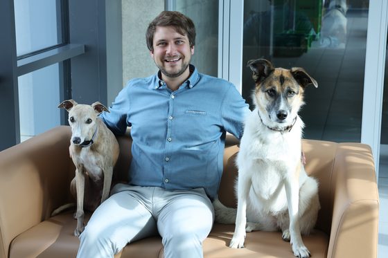 Emanuel F. sitzt mit Hunden auf einer Couch.