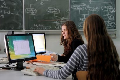 Zwei Mädchen arbeiten in einem Klassenzimmer am Computer