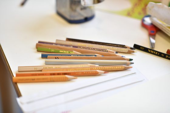 Verschiedene farbige Stifte liegen auf einem Schreibtisch.