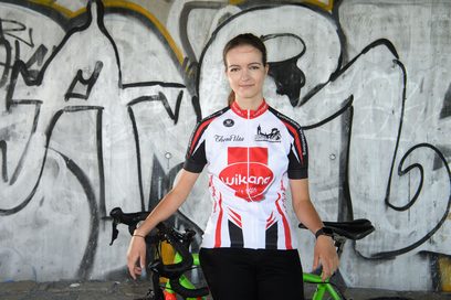 Die Gewinnerin des Geschichtswettbewerbs des Bundespräsidenten, Anne Grabo, steht mit ihrem Rennrad vor einer bemalten Wand. 