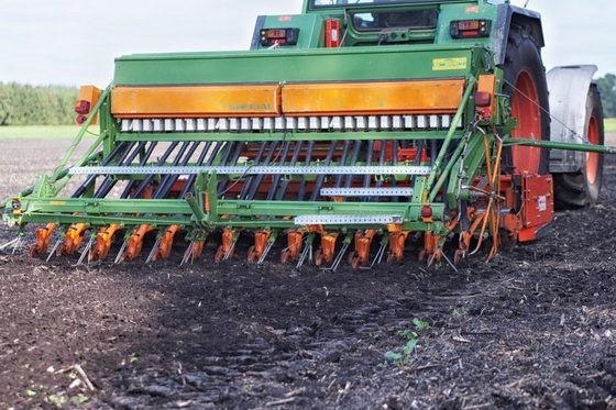 Landmaschine, die auf einem Feld Getreide aussäht.