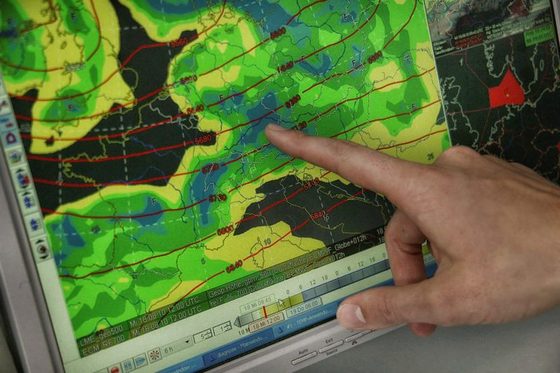Hand zeigt auf eine Wetterkarte von Europa auf einem Computerbildschirm
