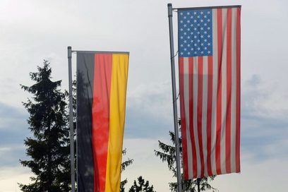 Die Flaggen von Deutschland und USA an einem Fahnenmast im Freien.