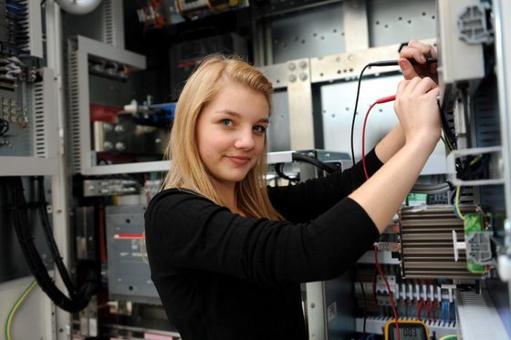 Eine junge Frau misst den Widerstandswert an einem Zentral-Wechselrichter. (Foto: Uwe Zucchi)