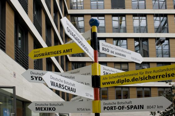 Viele Schilder vor dem Auswärtigen Amt in Berlin, auf denen Städte von deutschen Botschaften mit ihrer Entfernung stehen.