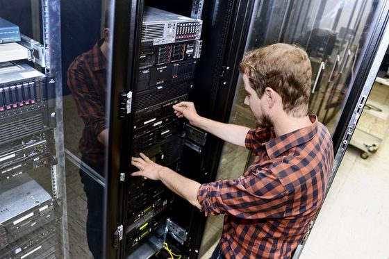 Ein Mann arbeitet am offenen Serverschrank. (Foto: Martin Rehm)