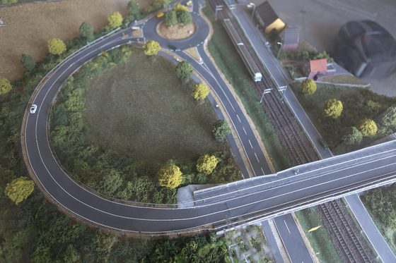 Vogelperspektive auf eine Straßenkreuzung mit Kreisverkehr und Brücke Modellbau