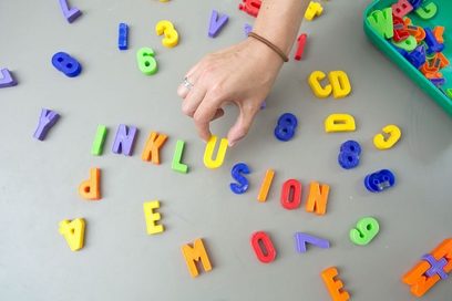 Eine Person legt das Wort &quot;Inklusion&quot; aus Magentbuchstaben.