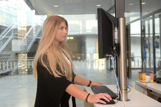 Junge Frau recherchiert etwas an einem Computer.