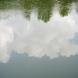 Wolken spiegeln sich im Wasser.