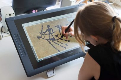 Eine junge Frau bearbeitet ein Bild von einem Fundstück digital.
