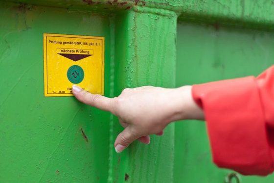 Detail: Abfallbeauftragte kontrolliert Prüfsiegel an Entsorgungscontainer (Foto: Axel Jusseit)