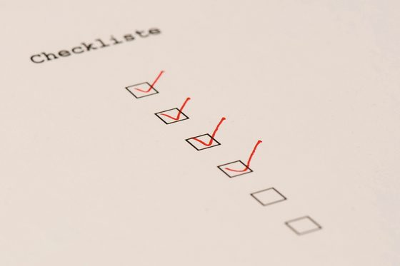 Detailaufnahme einer Checkliste mit sechs schwarzen Kästchen untereinander. Die vier oberen Kästchen wurden mit einem roten Stift angehakt. 