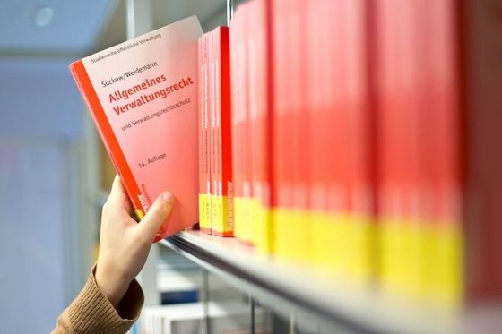 Studentin Verwaltungsmanagement sucht Fachbuch in der Bibliothek heraus. (Foto: Axel Jusseit)