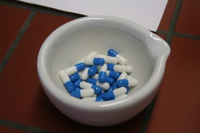 In einer weißen Keramikschale liegen mehrere, blau-weiße Tabletten.