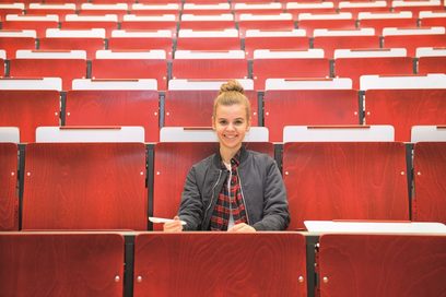 Eine Studentin sitzt in einem Hörsaal.