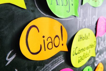 Blick auf verschiedenfarbige Sprechblasen aus Papier, auf denen auf verschiedenen Sprachen "Hallo" und "Wie geht es dir?" steht. (Foto: Julien Fertl)