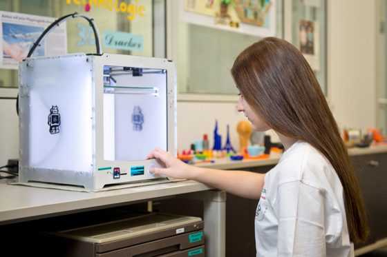 Eine junge Frau stellt einen 3-D-Drucker ein. (Foto: Hans-Martin Issler)
