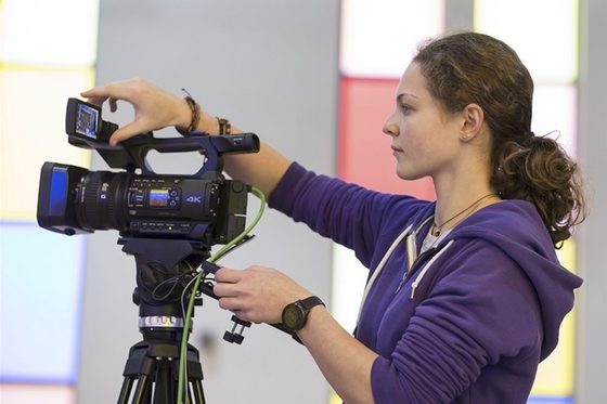 Eine Frau bedient eine Videokamera.