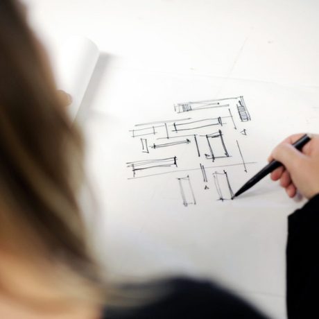 Eine Frau skizziert auf den vor ihr liegenden Zeichenblock mit einem schwarzen Stift Vierecke und Linien. (Foto: Bundesagentur für Arbeit)