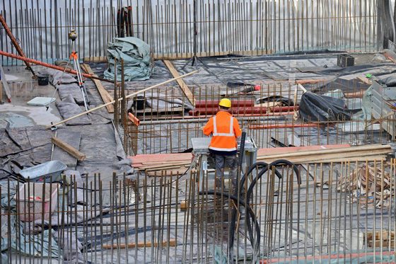 Ein Beton- und Stahlbetonbauer steht in einem Konstrukt aus Stahlpfeilern