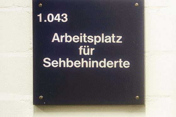 Schild mit Schrift: Arbeitsplatz für Sehbehinderte (Foto: Martin Rehm)