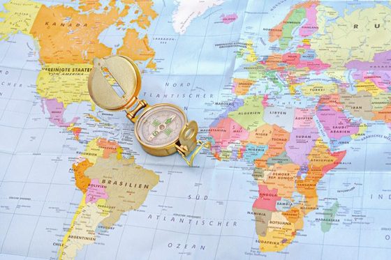 Ein Kompass liegt auf einer Weltkarte