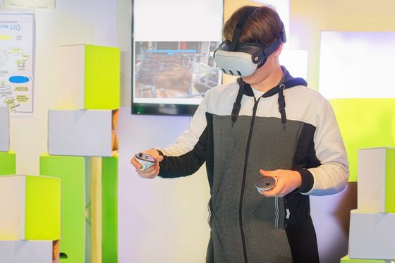 Ein junger Mann benutzt eine VR Brille.