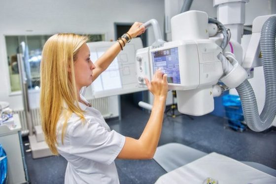 Eine junge Frau stellt ein Röntgengerät ein.