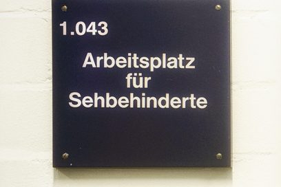 Schild mit Schrift: Arbeitsplatz für Sehbehinderte (Foto: Martin Rehm)