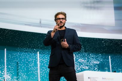 Max Härtl hält eine Rede auf einer Bühne.