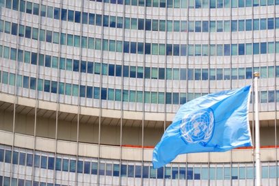 Wehende UN-Fahne vor einem Gebäude