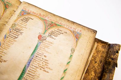 Altes Buch bzw. mittelalterliche Handschrift. Vergilbtes Papier, kunstvoll erstellt.
