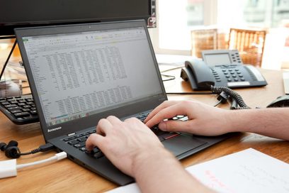 Ein Mann sitzt im Büro und arbeitet am Laptop