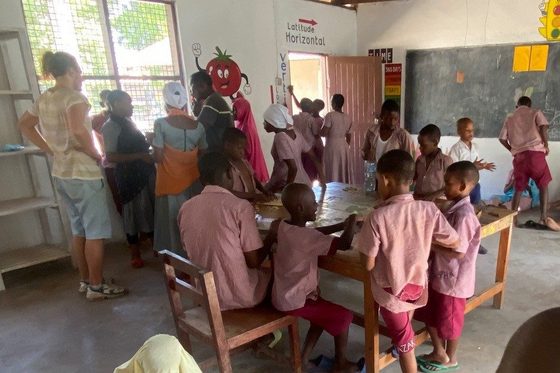 Elvis zusammen mit Schülerinnen und Schülern in einem Klassenzimmer einer Gehörlosenschule in Tansania