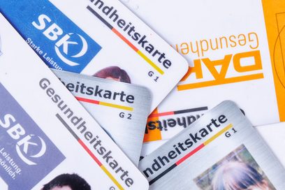 Das Foto zeigt mehrere Krankenversicherungskarten auf einem Haufen. (Foto: Julien Fertl)