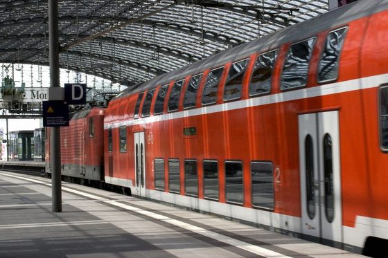 Ein doppelstöckiger roter Zug steht in einem überdachten Bahnhof.