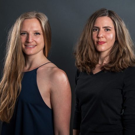 Ein Porträt-Bild von Isabella Hillmer und Laura Bücheler vor schwarzem Hintergrund