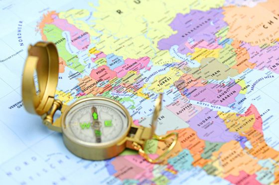 Ein Kompass liegt auf einer Weltkarte