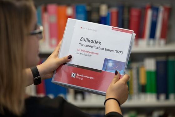 Die Studentin Melina Schildberg hält Fachliteratur in der Bücherei der Fakultät