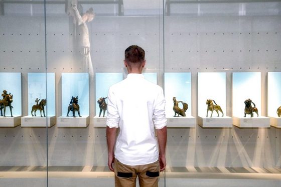 Ein Mann sieht sich Skulpturen in einem Museum näher an
