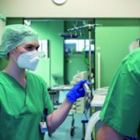 Eine Ärztin und ein Arzt mit Mundschutz im Operationssaal.