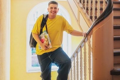 Ein Jugendlicher steht im Treppenhaus einer Berufsschule.