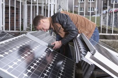 Ein Monteur schraubt Photovoltaikanlagen fest